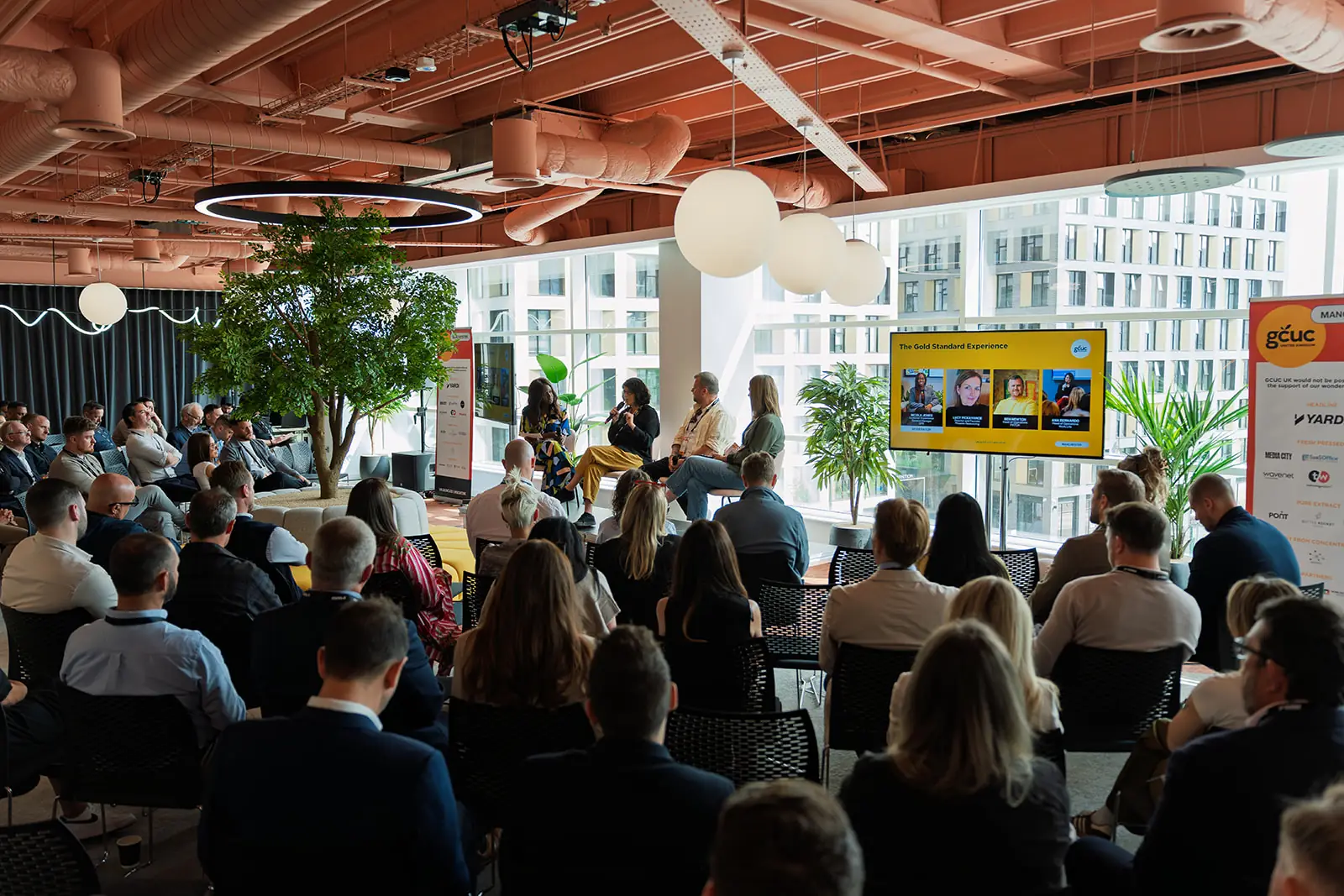 Operators seated for a GCUC Manchester panel discussion in a daylit coworking space